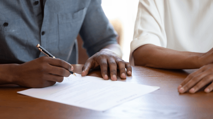 contrat étant signé par une personne sur un bureau